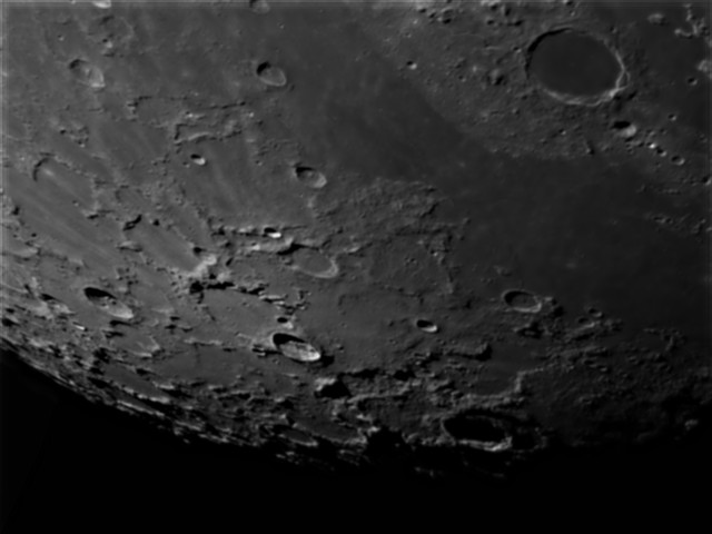 Cratère Platon (dans le coin supérieur droit de l'image) : son diamètre fait 100 km ; il est profond de 2000 m.